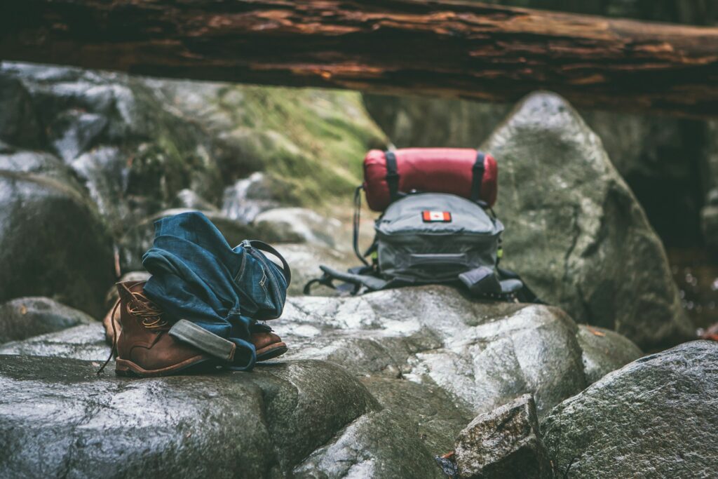 Two gray and orange backpacks on gray rocks at daytime